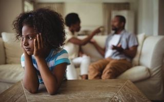 criança de costas para casal brigando
