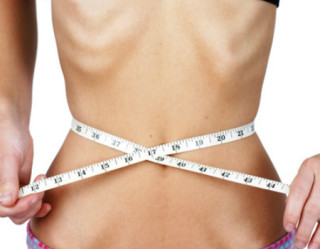 Pessoa magra medindo a cintura com fita métrica