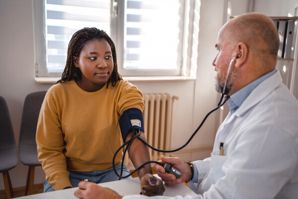 mulher jovem medindo a pressão arterial em médico