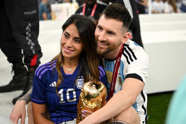 Antonela Roccuzzo ao lado de Lionel Messi, ambos seguram a taça da Copa do Mundo