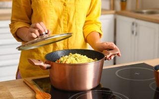 mulher abrindo uma panela de comida