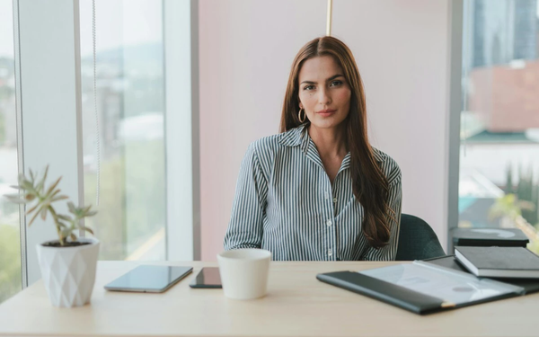 Mulher sentada em mesa em ambiente de trabalho
