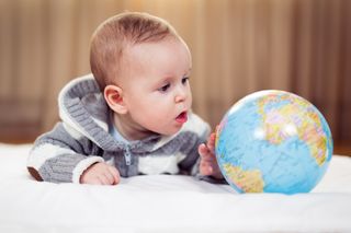 Bebê brincando com um globo da Terra
