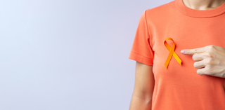 Pessoa com camiseta laranja aponta para a fita laranja colada no peito