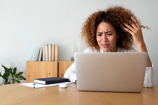 Mulher estressada em frente a um notebook