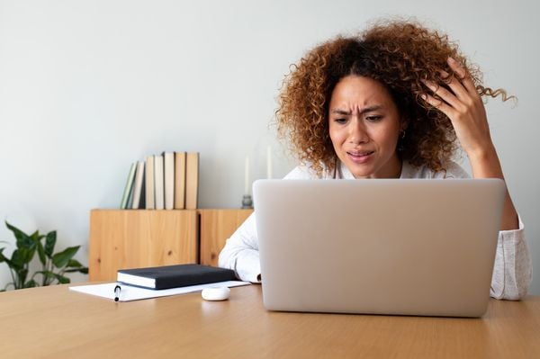 Mulher estressada em frente a um notebook