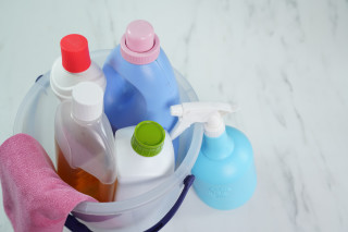Imagem de um balde transparente com produtos de limpeza em seu interior