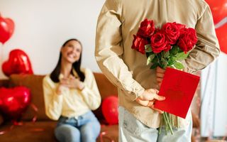 homem fazendo uma surpresa com buque de flores para a mulher