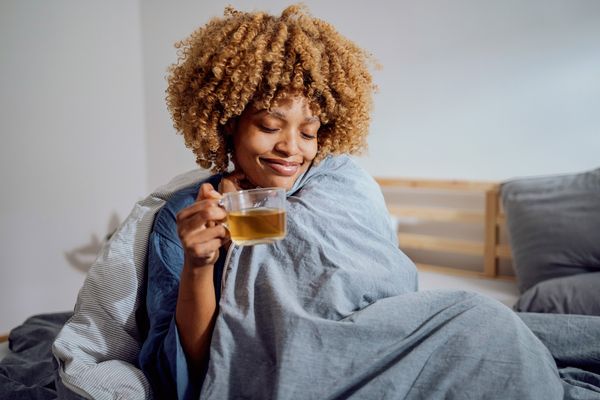 Mulher tomando chá na cama