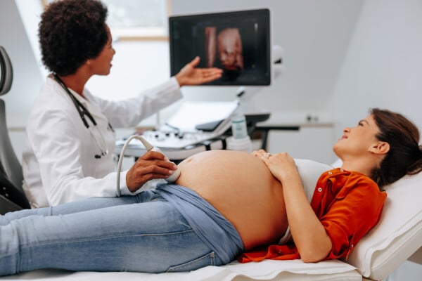 Mulher gravida realizando exame de ultrassonografia