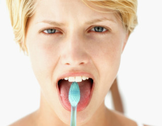 Mulher escovando a língua