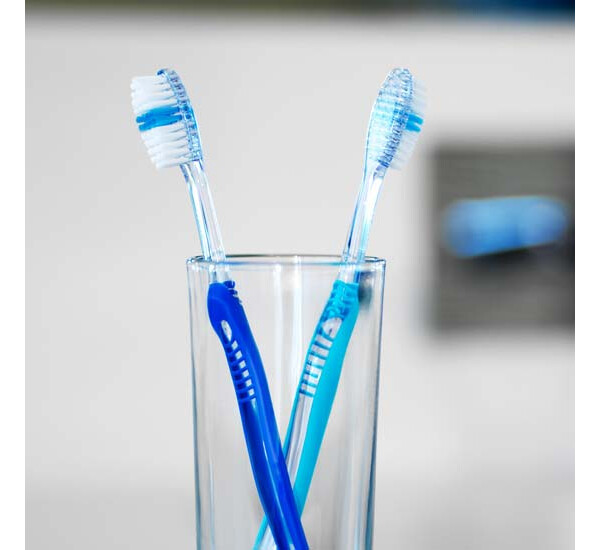 Escovas de dente em recipiente transparente