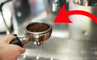 Imagem aproximada de pessoa fazendo café em máquina