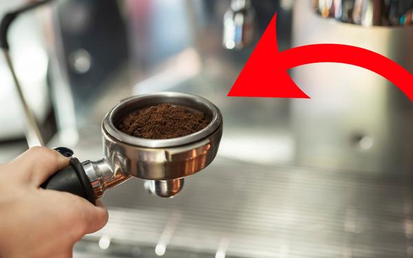 Imagem aproximada de pessoa fazendo café em máquina