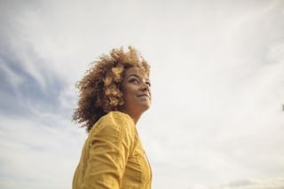 Mulher feliz e relaxada olhando para o horizonte