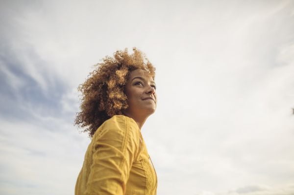 Mulher feliz e relaxada olhando para o horizonte