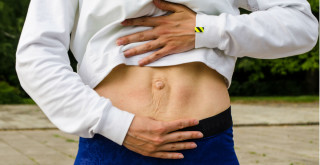 Mulher mostrando barriga com diástase abdominal