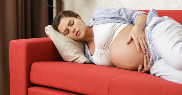 Mulher grávida deitada no sofá