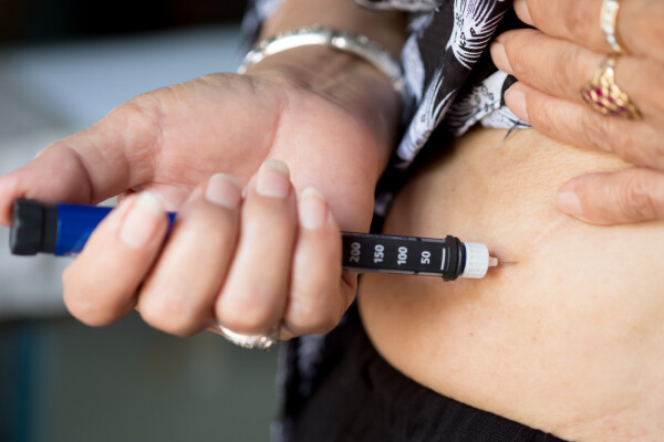 Imagem aproximada de mulher aplicando remédio para diabetes na barriga