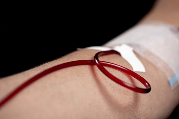 Braço de pessoa doando sangue