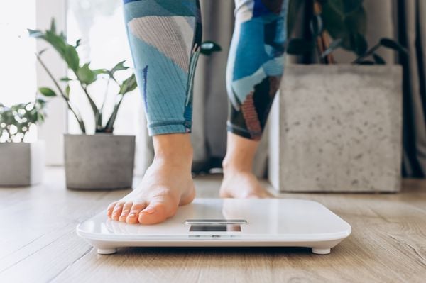 Pés femininos subindo em uma balança digital