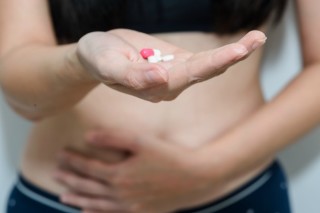 Mulher com a mão da barriga - Foto: Shutterstock