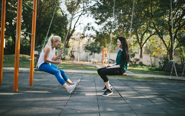 Duas mulheres felizes sentadas em balanços