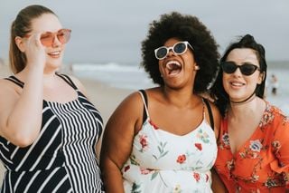 três mulheres sorrindo na praia