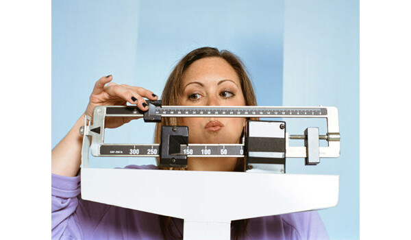 mulher chegando seu peso na balança
