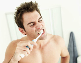 Homem escovando os dentes