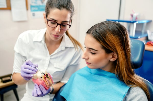 Dentista e paciente em consultório médico