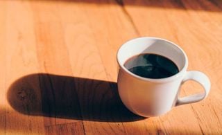 Xicara de café em mesa de madeira