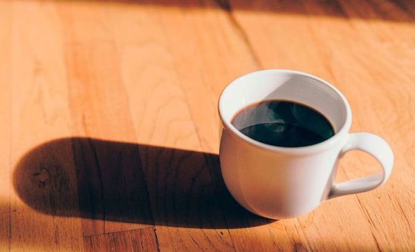 Xicara de café em mesa de madeira