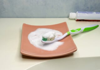 escova de dente em cima de bancada com bicarbonato de sódio em cima