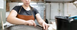 mulher faz buracos na tigela de barro em uma fábrica de cerâmica