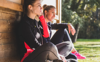Duas mulheres sentadas com roupas de academia