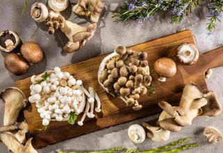 Diferentes tipos de cogumelos sobre tábua de madeira.
