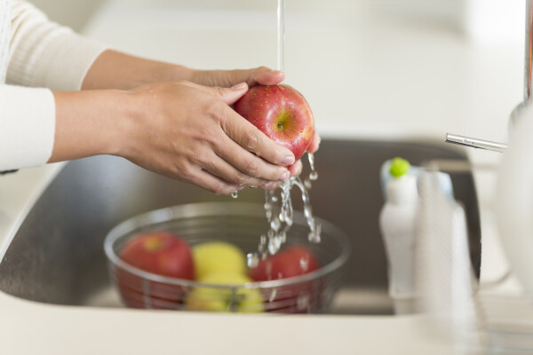 Mão de mulher lavando maçã