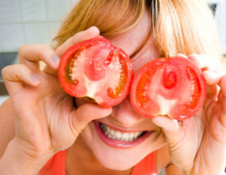 mulher com dois tomates na frente dos olhos