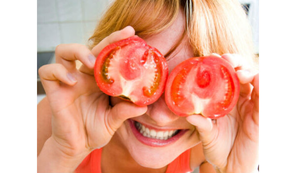 mulher com dois tomates na frente dos olhos