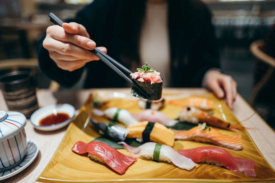 Mulher comendo comida japonesa