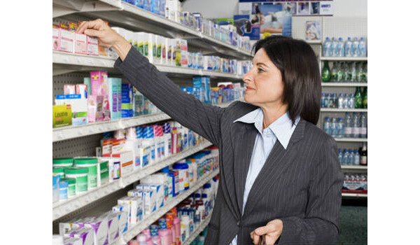 mulher pegando remédios na farmácia
