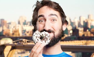 Homem segurando donut mordido