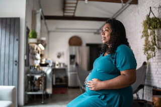 Mulher grávida tocando sua barriga e contemplando em casa