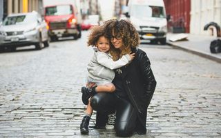 mãe abraçada com o filho no meio da rua