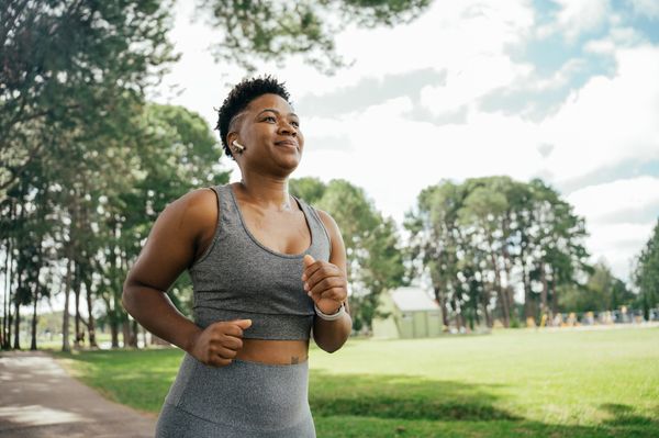 Mulher negra correndo em um parque