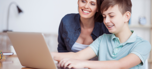 Mãe dá suporte ao filho durante o uso de um laptop