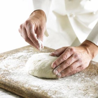 Homem preparando massa com farinha