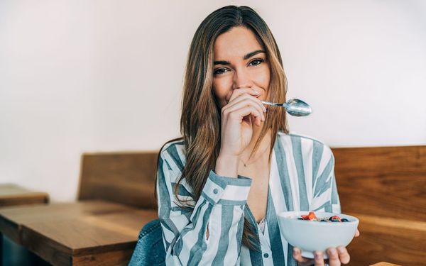 mulher segurando um prato na mão e comendo