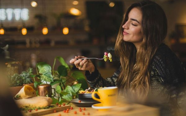 mulher comendo um prato de macarrão